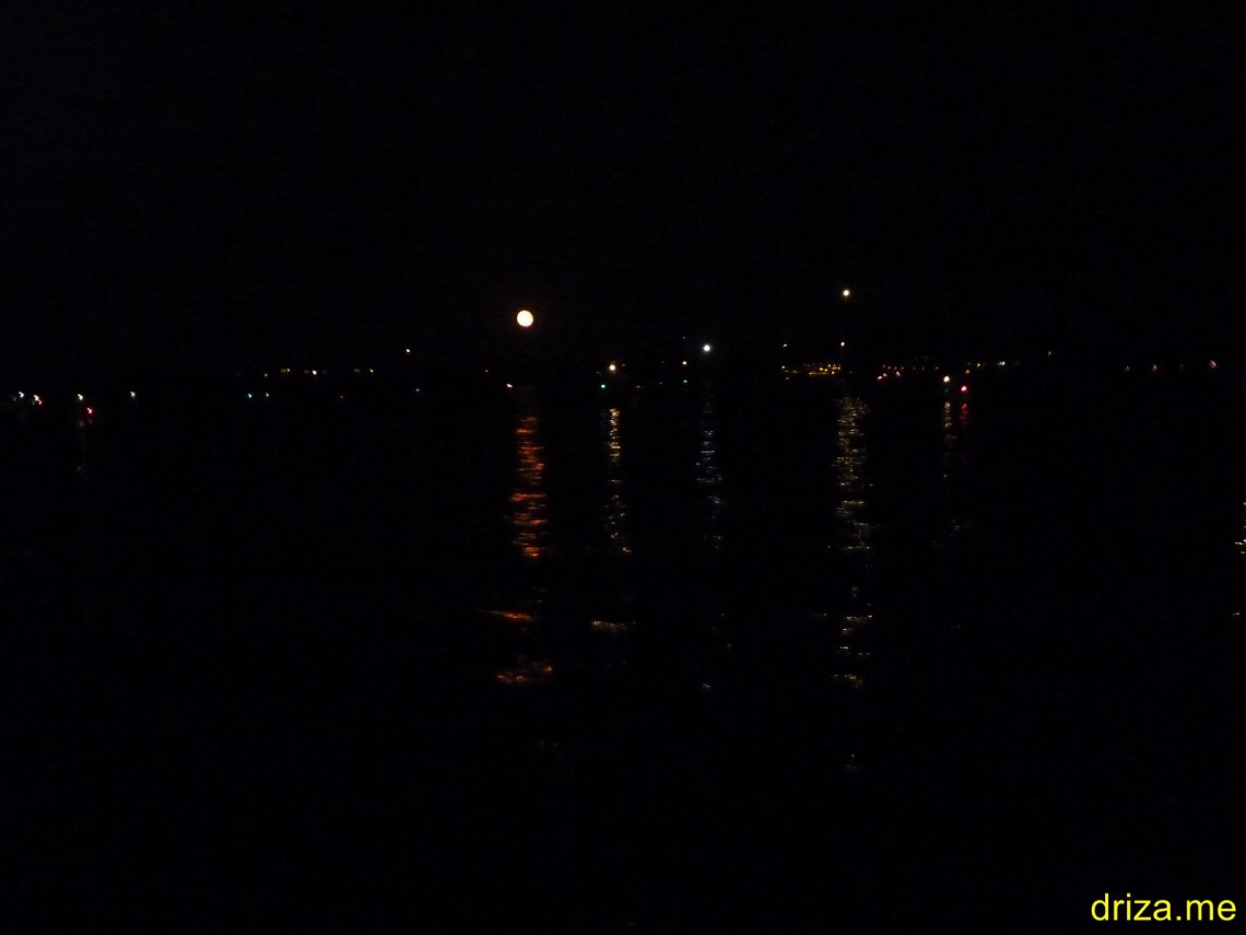 Todas esas luces son barcos saliendo de la bahía. El disco grande en el medio es la Luna